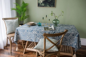 Detail of blue geometric triangle pattern tablecloth with tassels and matching cushion