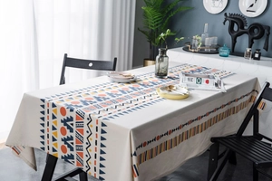 Detail of bohemian geometric print tablecloth with navy and orange patterns on beige fabric
