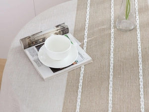 Detail of linen table cloth showing geometric embroidery and stitched fabric texture