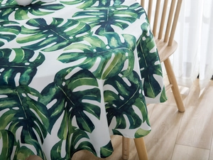Close-up of waterproof green monstera leaf print on premium white linen tablecloth