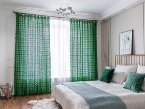 Close-up of vintage emerald green crochet lace curtain with geometric floral patterns
