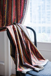 Detail of colorful bohemian striped cotton linen curtain fabric with white lace trim