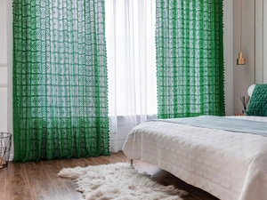 Detail view of green vintage crochet curtain with hollow geometric pattern and fringe