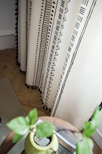 Detailed close-up of Bohemian cotton linen curtain with black tassel fringe and geometric print