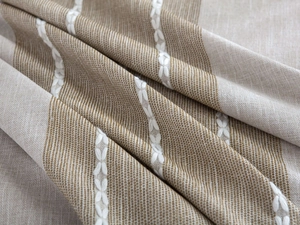 Detail of linen tablecloth fabric with stripes and white embroidered floral patterns