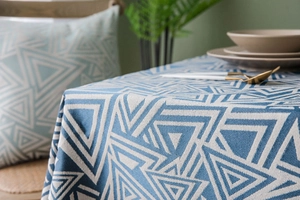 Detail of navy blue geometric pattern tablecloth and matching cushion in cotton linen