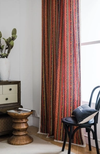 Detail of bohemian striped cotton linen curtain with white lace trim and ethnic patterns