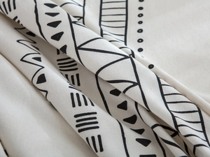 Macro shot of heavy cotton linen fabric showing black geometric prints and thick texture