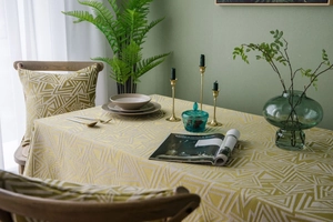 Detail der Jacquard-Tischdecke und passende Kissen mit gelben geometrischen Dreiecksmustern