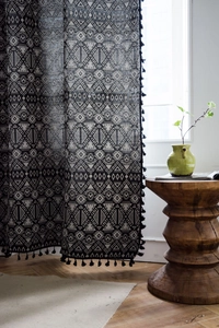Close-up of geometric pattern jacquard curtain with black tassel fringe detail