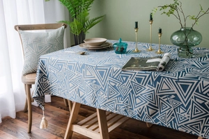 Detail of blue geometric triangle tablecloth with elegant white decorative tassels