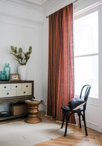 Detail of bohemian striped cotton linen curtain with woven lace trim and warm tones