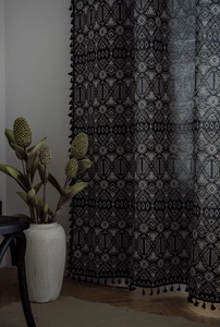 Detail of bohemian geometric jacquard curtain with black tassels and premium cotton linen texture
