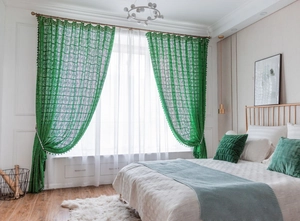 Detailed close-up of emerald green crochet curtains featuring vintage bohemian fringe details