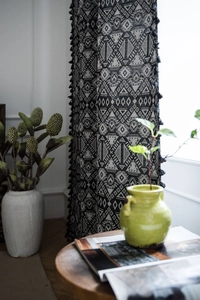 Close-up of black and white geometric jacquard fabric with elegant tassel trim detail