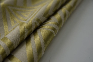 Detailaufnahme von gelb-beigeem Jacquard-Stoff mit geometrischen Dreiecksmustern