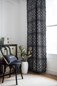 Detailed view of bohemian black and white geometric curtain fabric with elegant fringe tassels