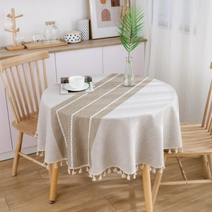 Minimalist cotton linen round tablecloth with brown stripe and tassels on a dining table