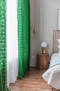 Detailed macro of green crochet hollow curtain with geometric patterns and fringe edges
