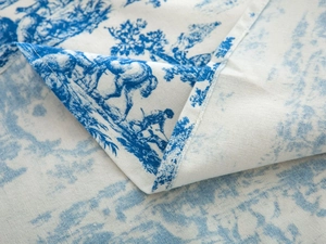 Detail of blue toile de jouy print on cotton linen fabric with stitched hem