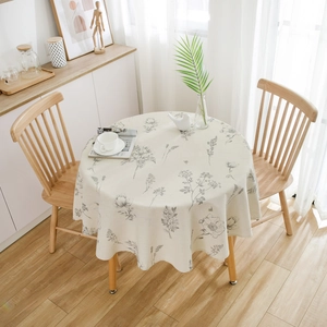 Detail of round linen tablecloth with floral pattern in a cozy dining room setting