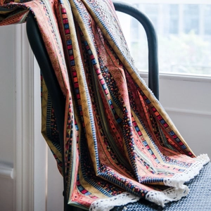 Bohemian striped linen window curtain with white lace edge hanging on a chair