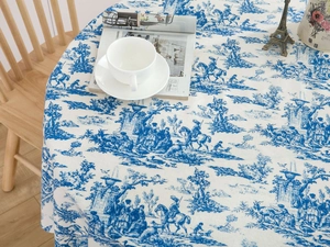 Detailed blue Toile de Jouy floral pattern on round beige tablecloth with pastoral scenery