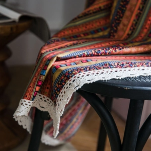 Bohemian striped cotton linen curtain with white lace edge hanging on a chair