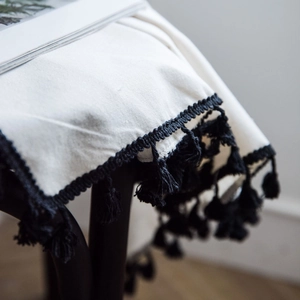 Minimalist white semi-sheer curtain fabric with black fringe tassels in a boho style