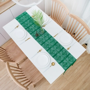 Detail of dark green crochet table runner showing intricate hollow out lace patterns