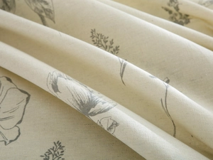 Close-up of beige cotton linen tablecloth featuring grey hand-drawn floral patterns