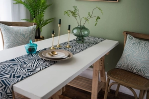 Detail view of navy blue geometric jacquard table runner on a white dining table