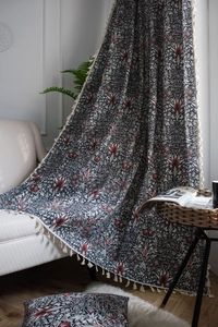Detailed macro view of the intricate floral paisley patterns and white fringed tassels