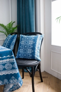 Detalle del mantel y cojín azul vintage con motivos de encaje en mezcla de algodón y lino