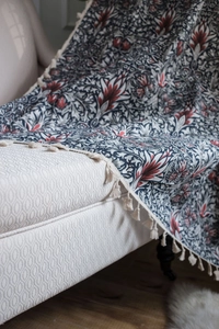 Close-up of cotton linen floral blanket with intricate Paisley patterns and beige tassels
