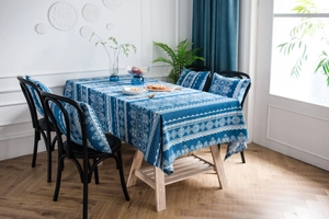Detalle de mantel vintage de lino azul con estampado de encaje y cojines de silla a juego