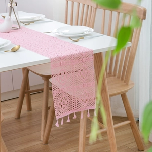 Close-up of pink crochet lace table runner with intricate hollow patterns and tassels