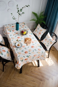 Detailansicht der Pfirsich-Tischdecke und passender Kissenbezüge bei sanftem Sonnenlicht