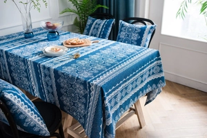 Detalle del mantel de lino y algodón azul con diseño de encaje y cojines de silla a juego
