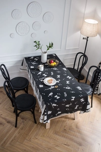 Detail view of a music-themed tablecloth with piano keyboard border and musical notes