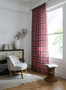 Detail of red Bohemian cotton linen curtain with geometric patterns and tassel trim