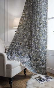Detail of bohemian cotton linen curtain with paisley floral pattern and white tassels