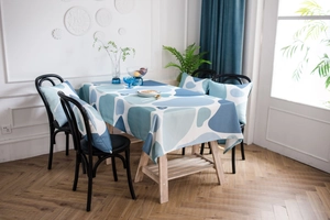 Detail view of yellow and blue pebble print tablecloth with matching cushions in a room