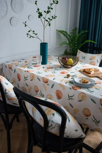 Detailansicht der elfenbeinfarbenen Tischdecke mit Pfirsichmuster und Polsterkissen