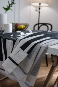 Detail view of cotton linen tablecloth with black and white piano key and music note patterns