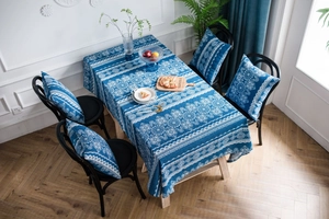 Detalle de mantel de algodón y lino con estampado de encaje azul y funda de cojín