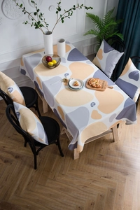 Detail of yellow pebble print tablecloth and matching cushion covers in a cozy home setting