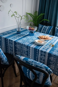 Textura detallada del mantel de lino azul con patrones de encaje floral blanco