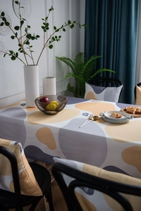 Detail of Nordic style tablecloth and chair pads with yellow abstract pebble patterns