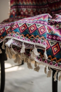 Detail of red Bohemian cotton linen curtain featuring geometric patterns and white tassels